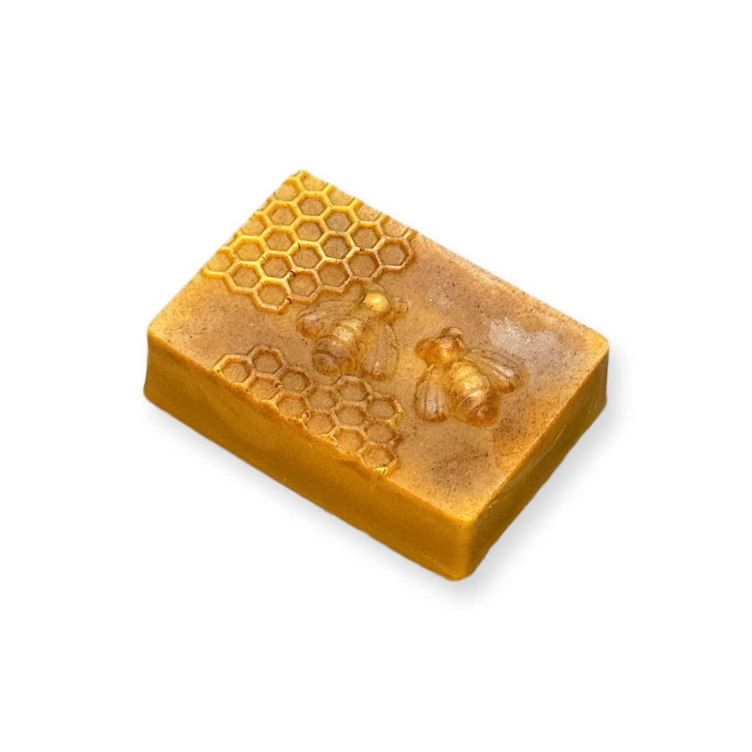 Organic amber-colored soap bar with honeycomb and bee design on a white background