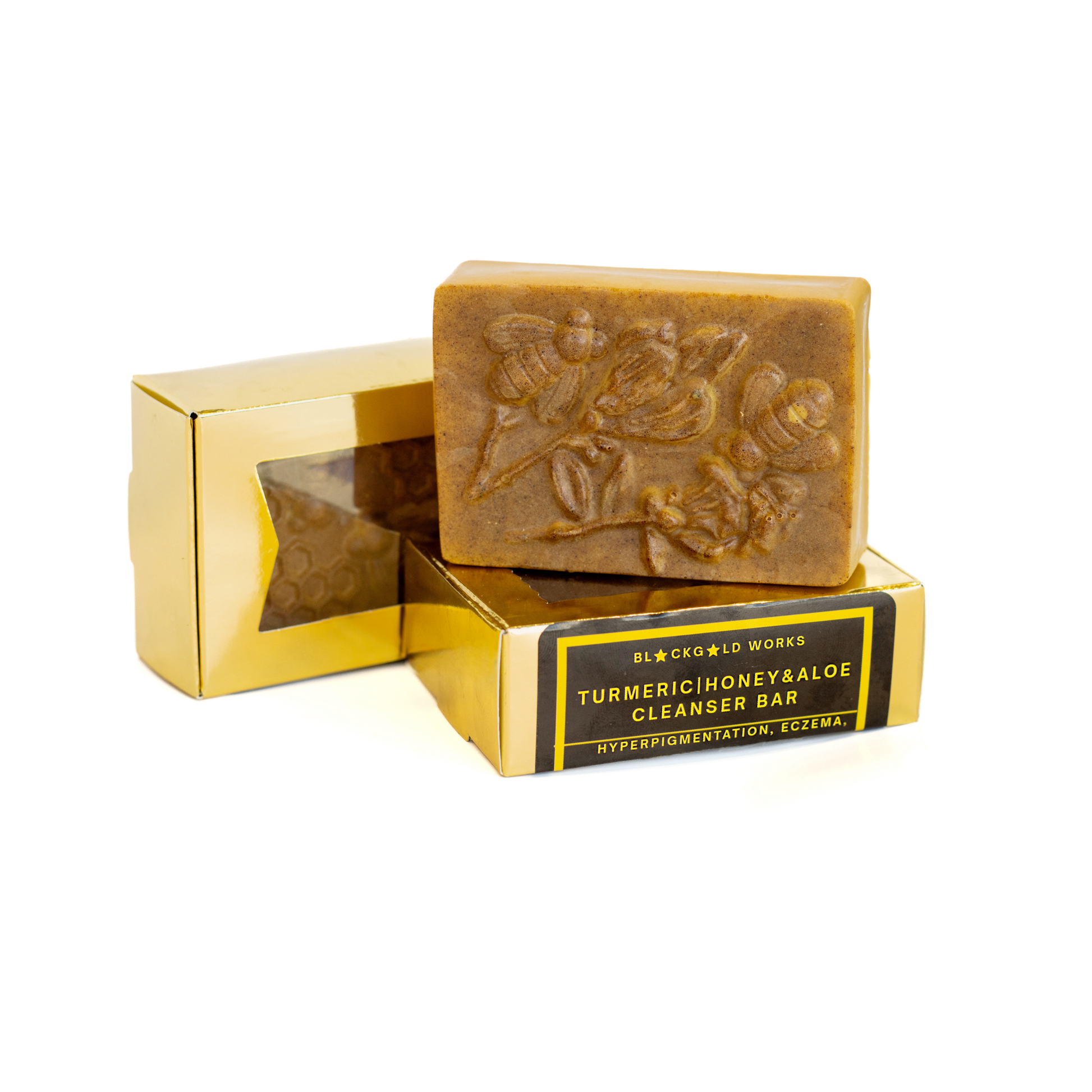 Golden turmeric  honey aloe soap bar with floral embossed design, standing on golden box with black gold label.